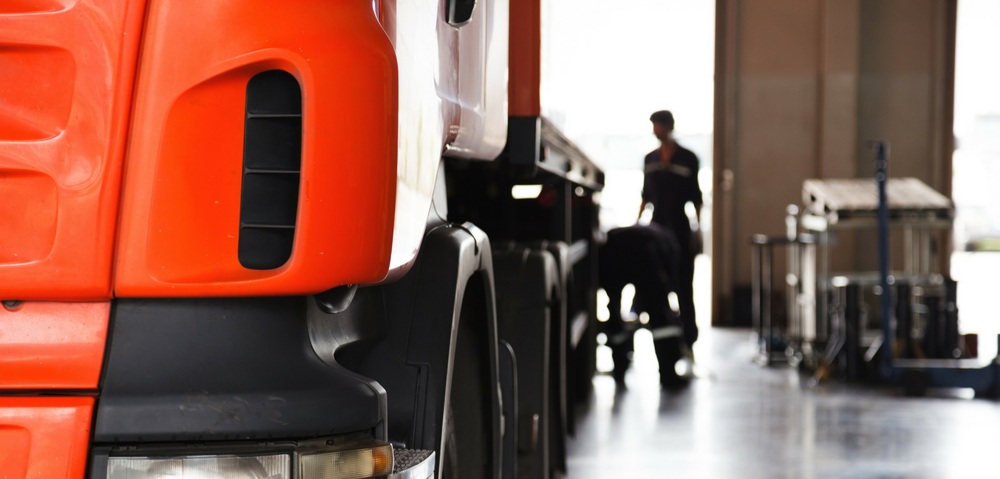 Diesel Technology- Orange big truck with two males changing the tire