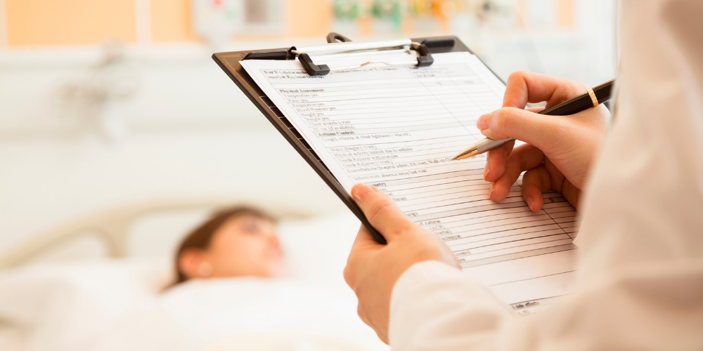 Health Professions- nurse with clipboard looking at a patient in a hospital bed