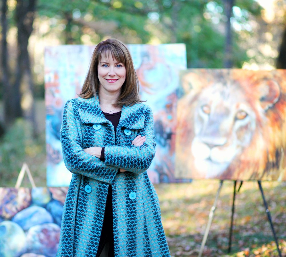 Artist Shelley Gentry poses for a photo in front of her art pieces.