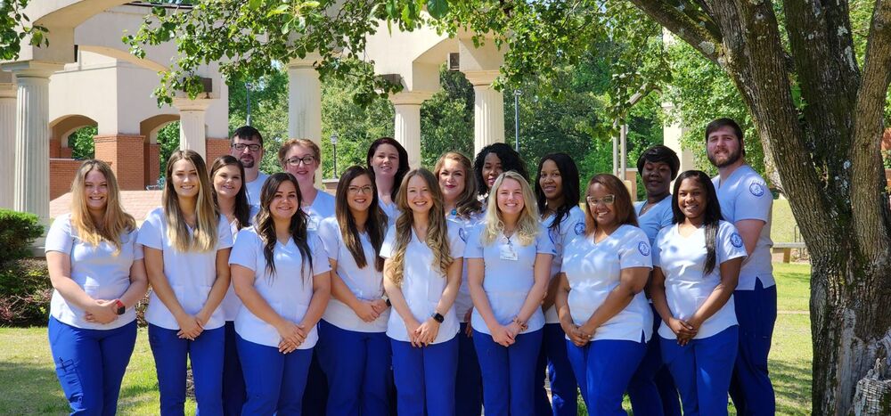 Practical Nursing- Female in white scrubs with a blue stethoscope around her neck